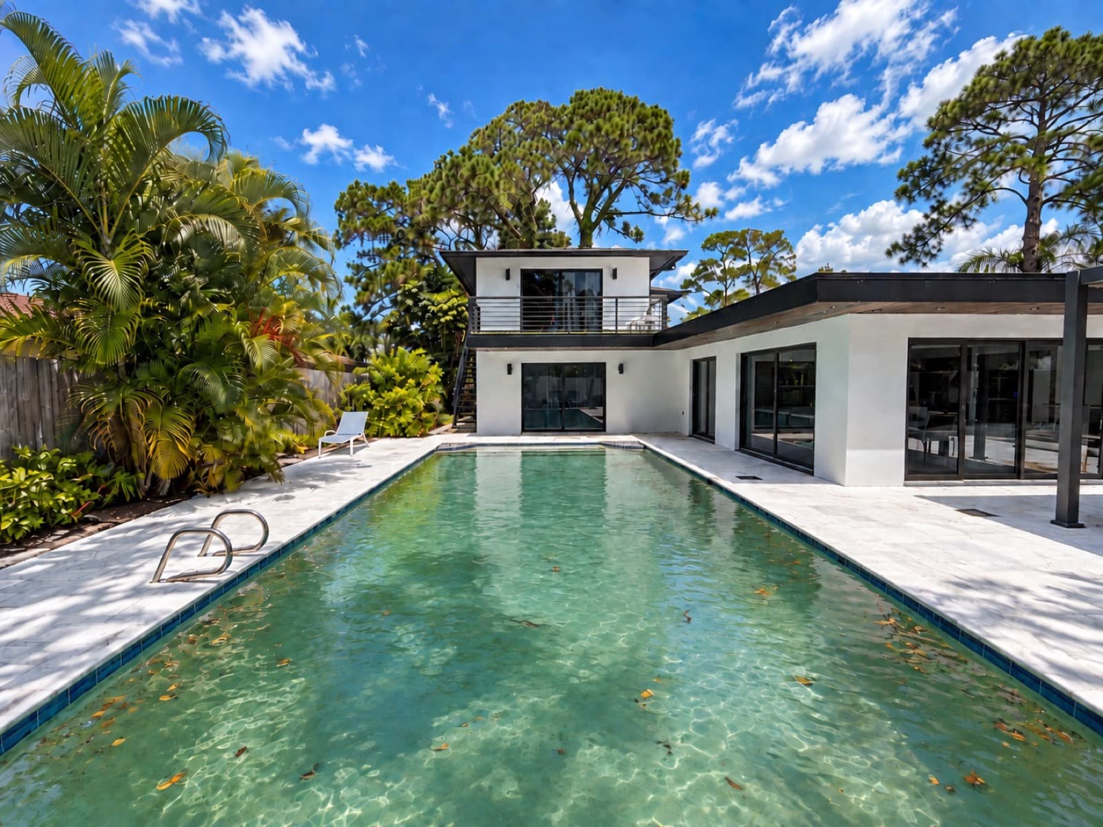 Pool before a Tarpon Pool Cleaning visit — cloudy, leaf-strewn water